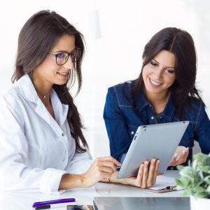 doctor and her patient choosing mammary prosthesis in the office scaled